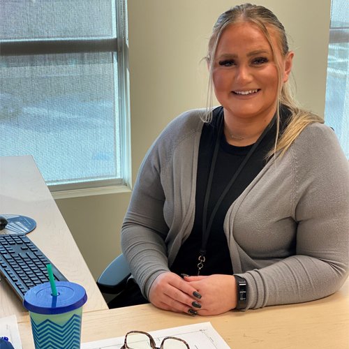 A recreation attendant smiles from her desk.